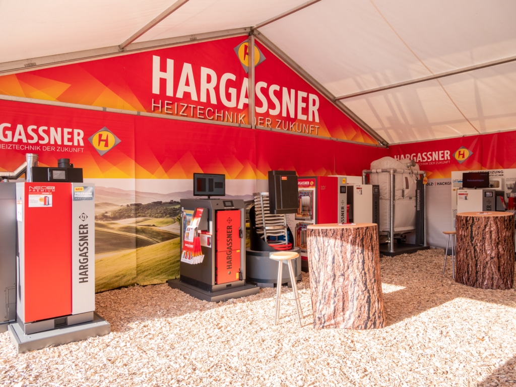 Hargassner-Kessel im Messezelt Land & Forst Wieselburg mit Baumstümpfen als Dekoration | Hargassner