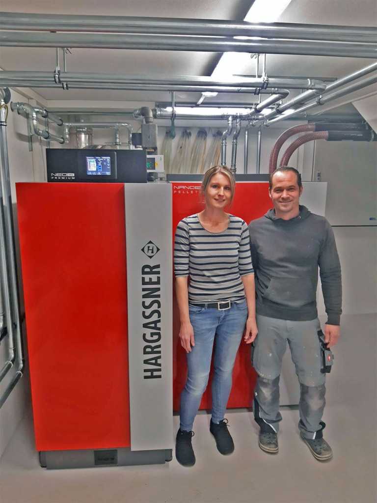 Familie Legat mit ihrem neuen Biomasse-Heizsystem - Referenz Kombikessel Pellets Scheitholz | Hargassner