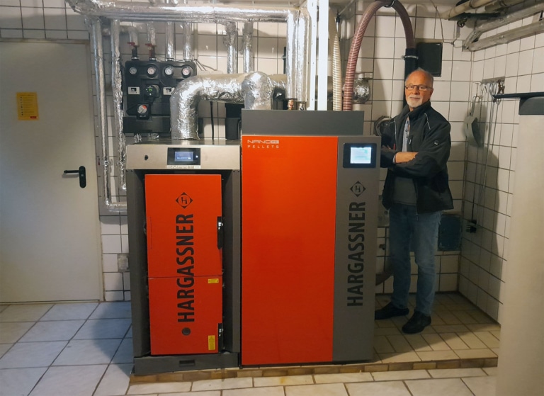 Herr Hochreiter mit seinem neuen Biomasse-Heizsystem - Referenz Kombikessel Pellets Scheitholz | Hargassner