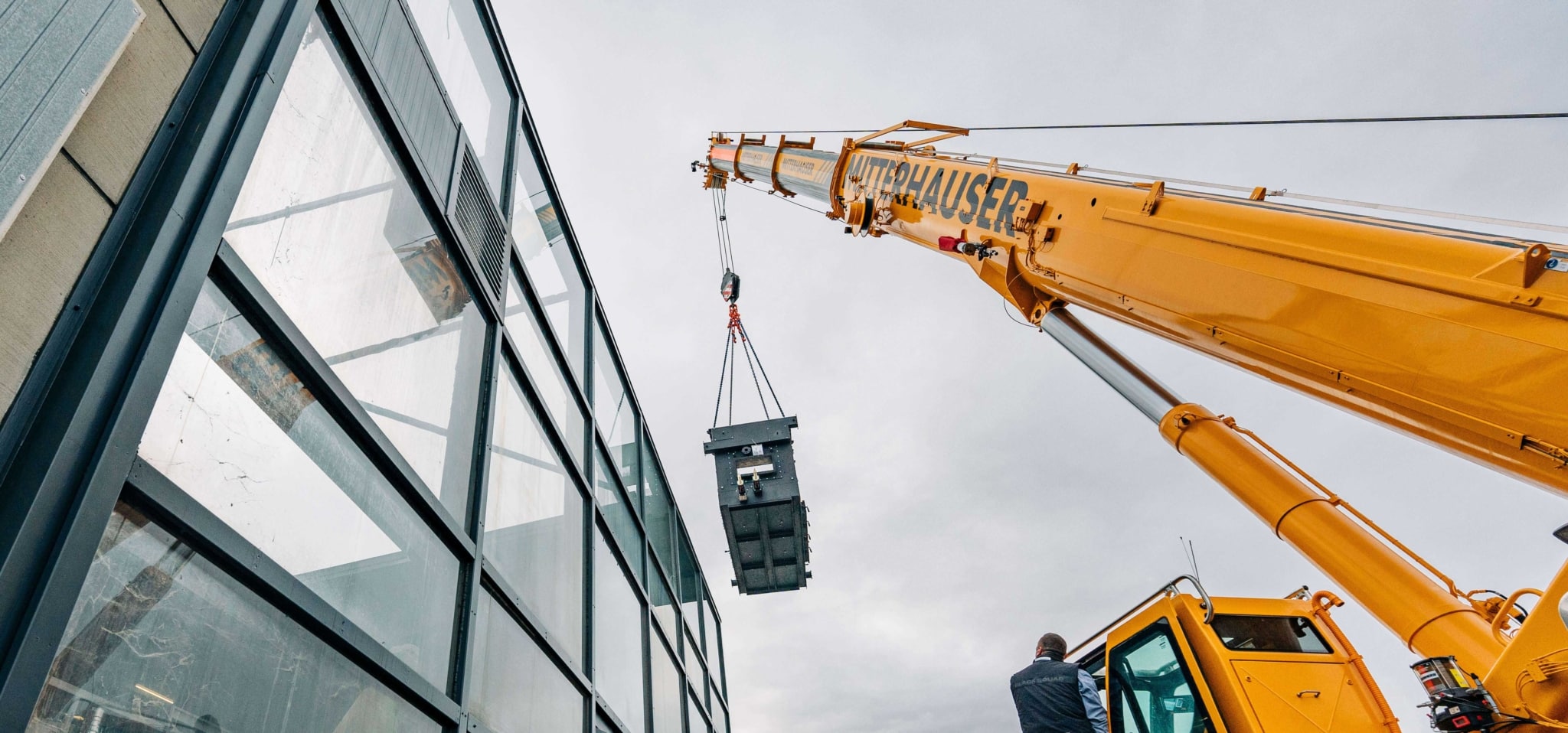 Kran hebt Magno SR Industriekessel in den künftigen Heizraum | Referenz Hargassner