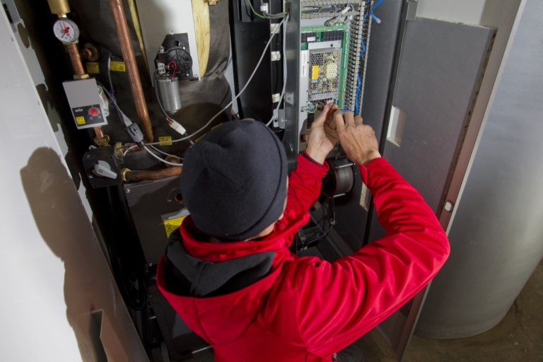 Technicien en train d'agir sur une chaudière Nano-PK