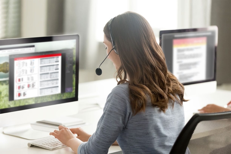 Une femme avec un casque sur son PC Assistance à la clientèle