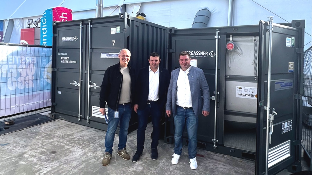 Hargassner Geschäftsführung Markus (rechts) und Anton Hargassner jun. (Mitte) mit Peter Teuschl vor den Powerboxen bei der Tennishalle am Heumarkt | Hargassner