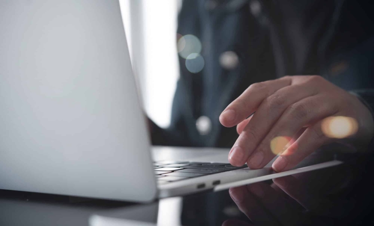 Hand on laptop presses Enter - Download | Hargassner Academy