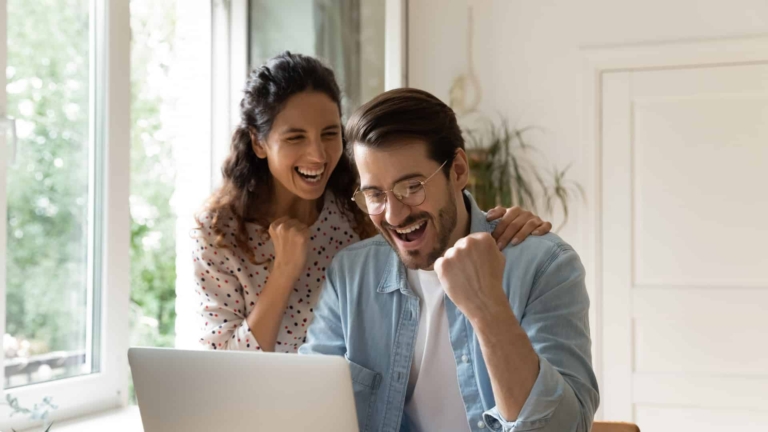 Paar vor Laptop lacht und freut sich | Hargassner