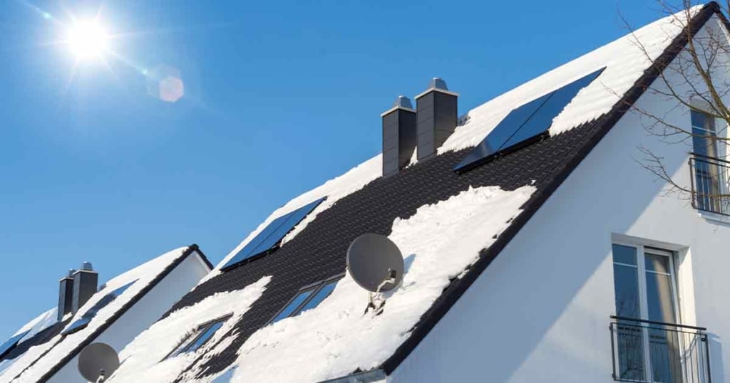 Solaranlagen auf einem verschneiten Dach im Winter | Hargassner