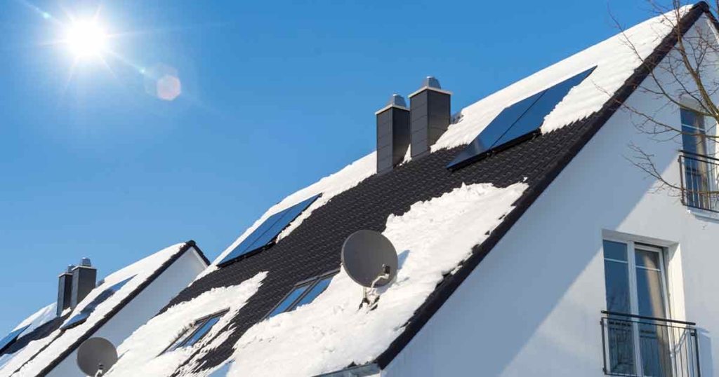 Solar panels on a snow-covered roof in winter | Hargassner