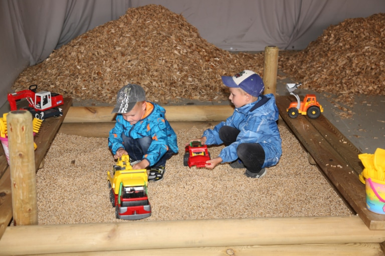 Kinder spielen in Sandkasten, der mit Pellets gefüllt ist - Hausmesse zum 35. Jubiläum | Hargassner