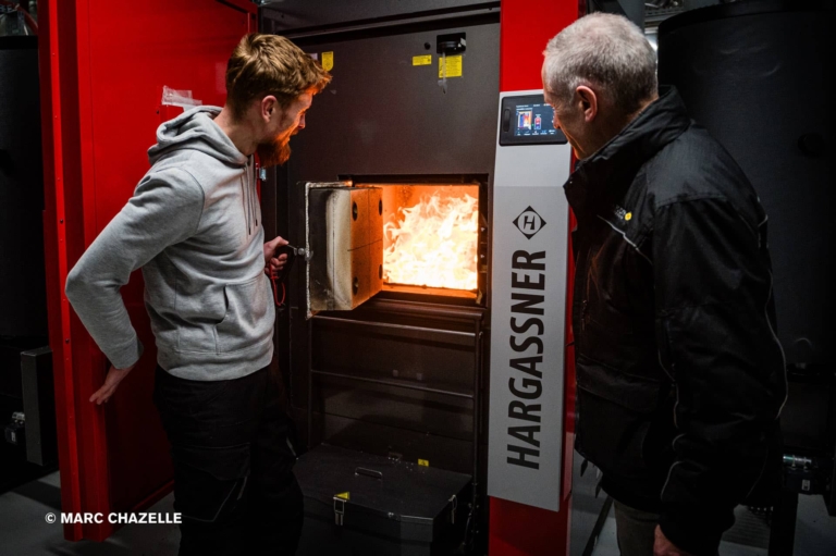 2 techniciens devant le foyer de combustion d'une chaudière Eco-PK 330 kW allumé