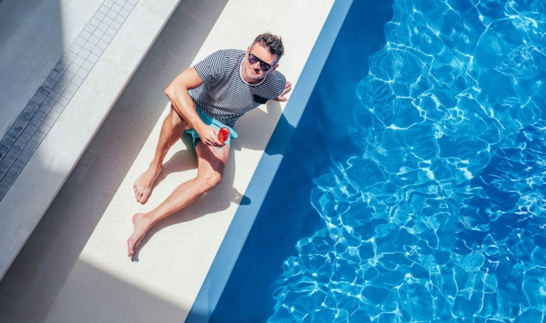 Mann sitzt entspannt am Pool und bewahrt einen kühlen Kopf | Hargassner