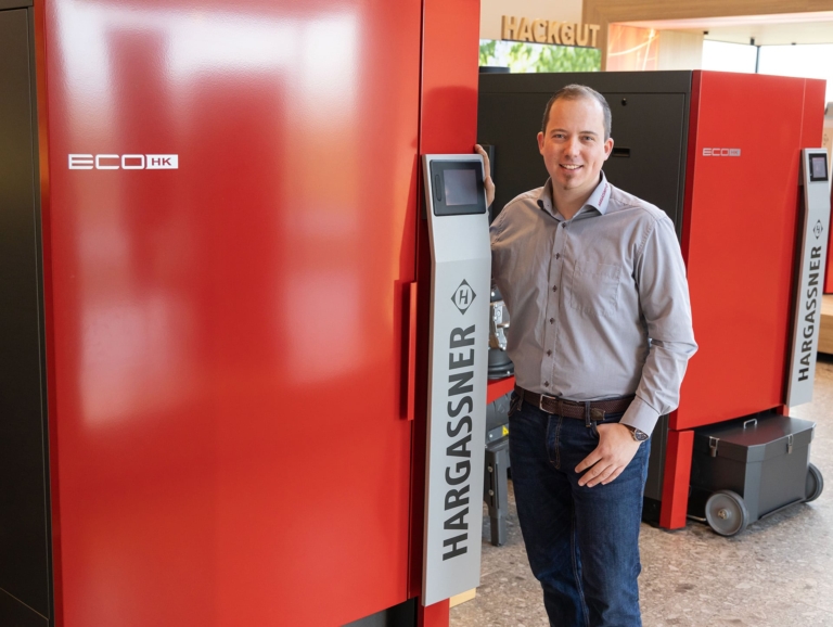 Stefan Kopp, CEO Amérique du Nord, à côté de la chaudière à copeaux de bois Eco-HK