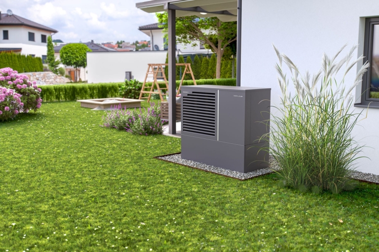 Außenansicht Einfamilienhaus, Blick auf Garten und Außenmodul Hargassner Wärmepumpe Airflow-M