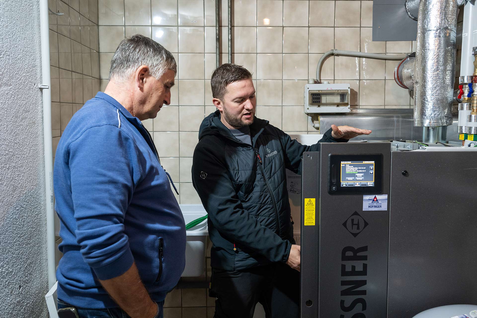 Servicetechniker erklärt dem Kunden Manfred Heizinger die neue Pelletheizung Nano-PK | Referenz Hargassner