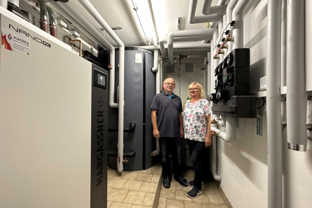 The Schäffer family in the boiler room with the new Nano-PK pellet heating system | Reference Hargassner