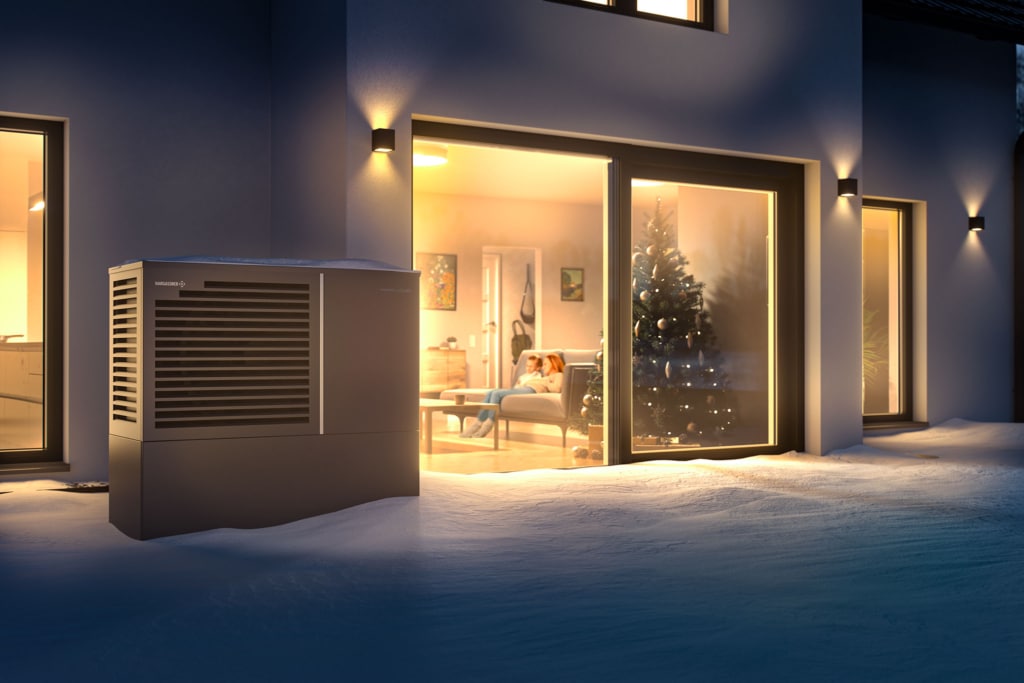 Maison unifamiliale vue de l'extérieur en hiver, vue par la fenêtre dans le salon avec sapin de Noël - module extérieur Hargassner pompe à chaleur Airflow-M