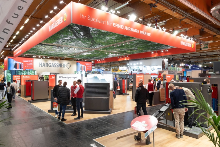 Foto vom neuen Messestand auf der WEBUILD Wels 2025, Messebesucher betrachten Hargassner Heizlösungen