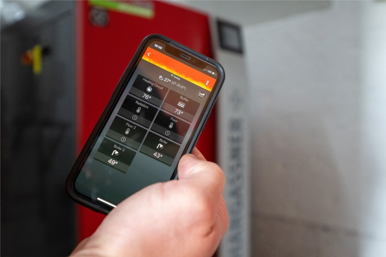 Mobile phone with smart heating control app from Hargassner