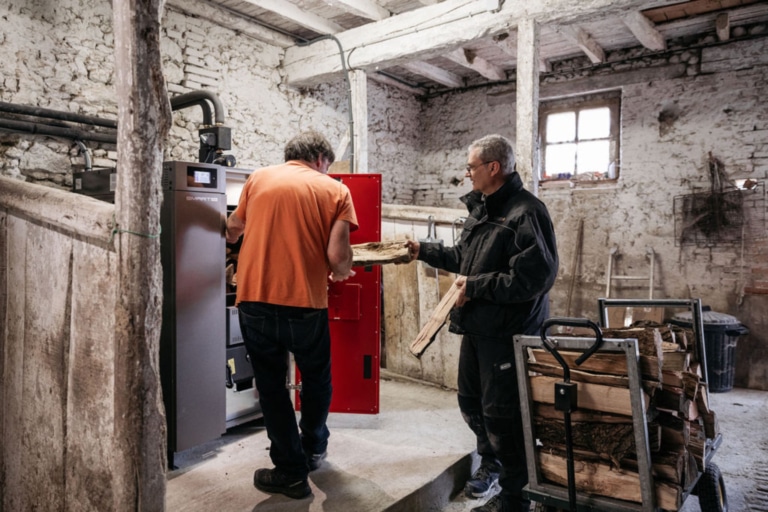 l'installateur tend une bûche au client