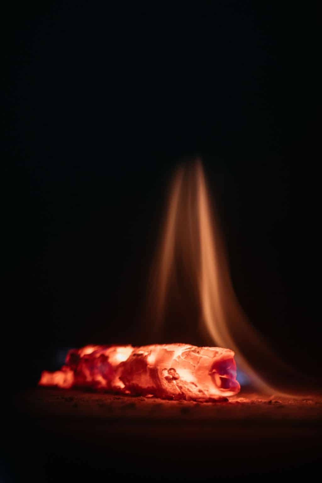 gros plan sur une braise rougeoyante et une flamme