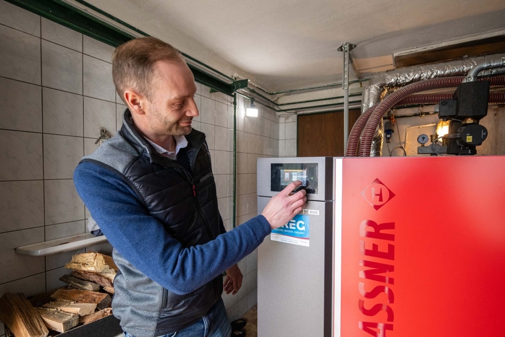 Mitarbeiter von Hargassner bedient Kombikessel Smart-DUO - Bauernhaus Kasinger | Referenz Hargassner