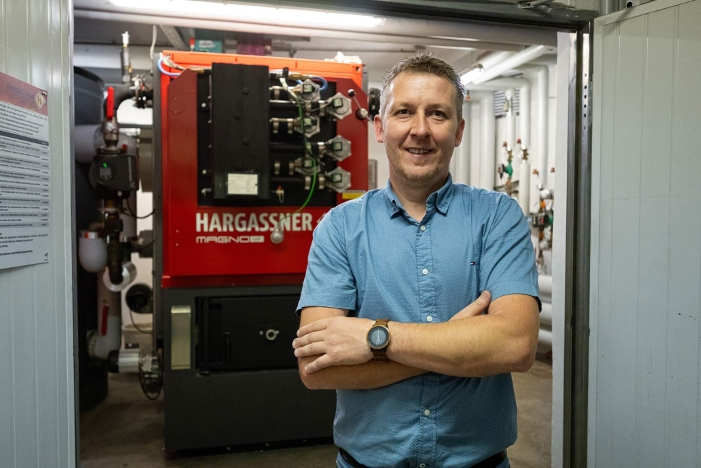 Managing Director Manfred Temper in front of Magno-Heizung | Reference Hargassner