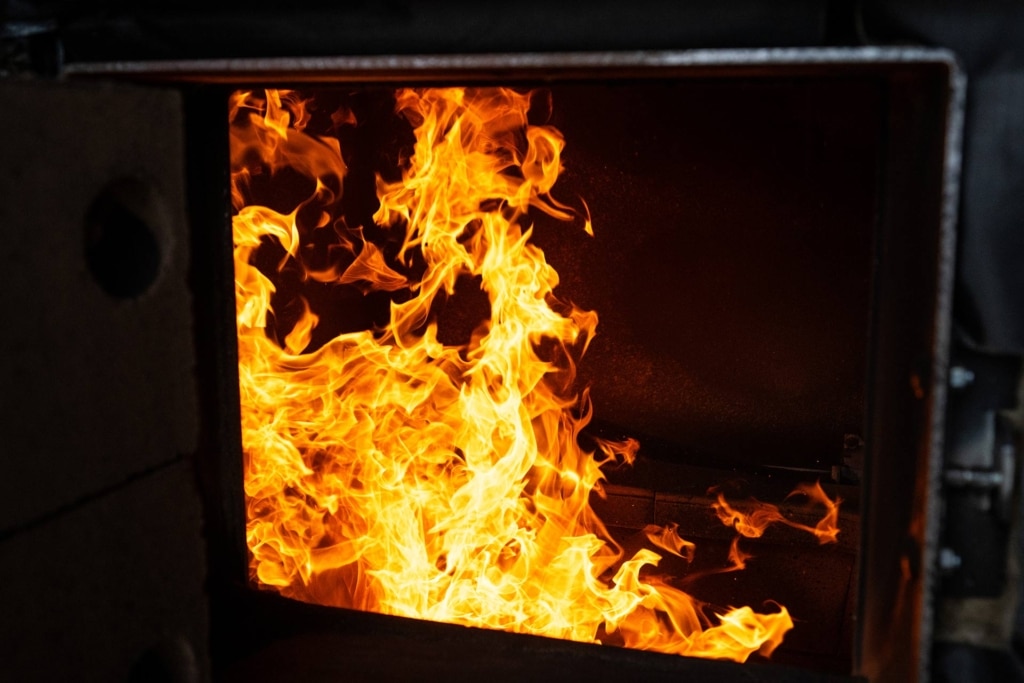 Flamme dans la chambre de combustion de la chaudière à bois déchiqueté Eco-HK chez Metallbetrieb Knoblinger | Référence Hargassner