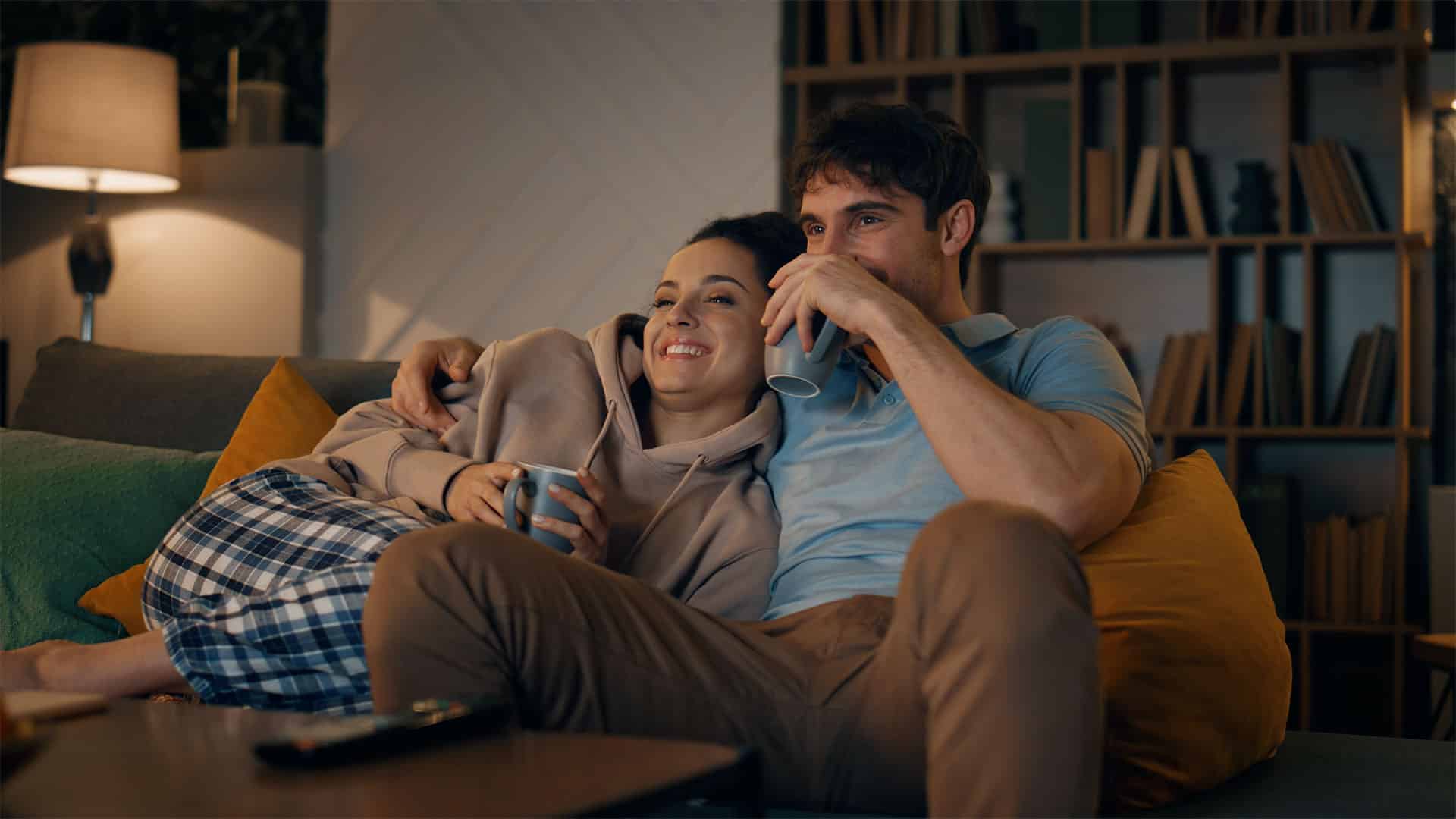 Couple sitting happily and relaxed on the sofa in winter, living room