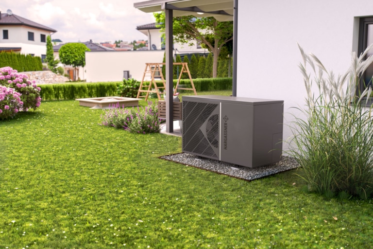 Außenansicht Einfamilienhaus, Blick auf Garten und Außenmodul Hargassner Wärmepumpe AirPro