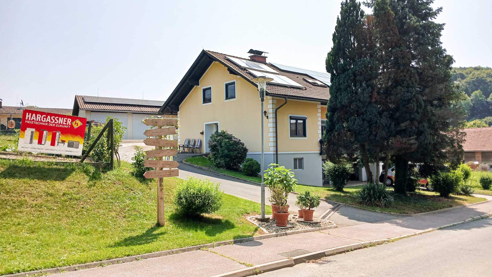 Außenansicht eines Einfamilienhauses mit Hargassner-Anlage und Gartenbereich vor dem Gebäude, Referenz Hargassner
