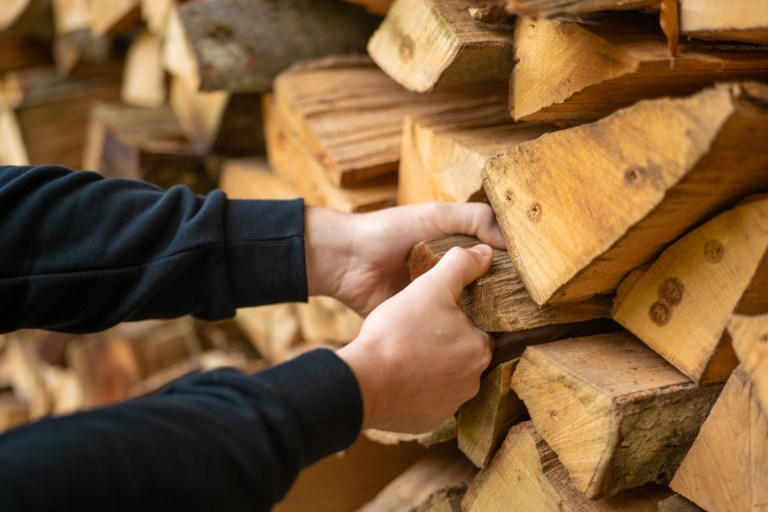 homme prenant une buche de bois en main